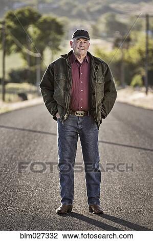 Caucasian farmer standing on rural road View Large Photo Image Stock Image - Caucasian farmer standing on rural road. Fotosearch