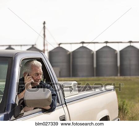 Stock Photo - Caucasian farmer talking on cell phone. Fotosearch