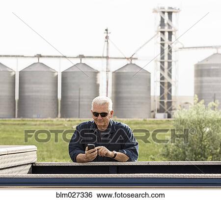 Caucasian farmer using cell phone View Large Photo Image Stock Photograph - Caucasian farmer using cell phone. Fotosearch