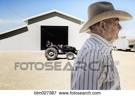 Caucasian farmer walking past barn View Large Photo Image Stock Photo - Caucasian farmer walking past barn. Fotosearch