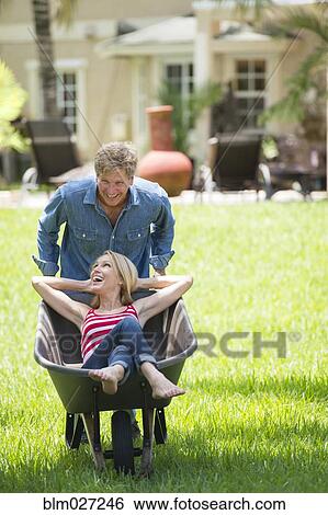 Caucasian man pushing girlfriend in wheelbarrow View Large Photo Image Stock Photograph - Caucasian man pushing girlfriend in wheelbarrow. Fotosearch