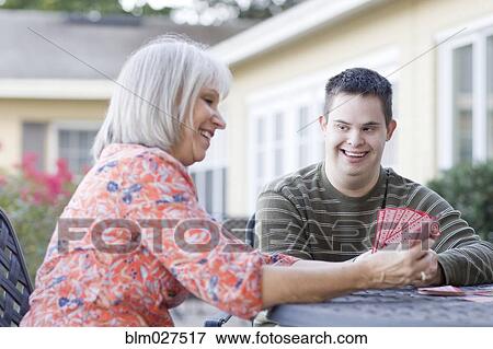 Stock Photo - Caucasian mother and disabled son playing cards. Fotosearch