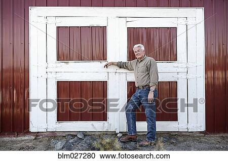 Caucasian rancher standing by barn View Large Photo Image Stock Image - Caucasian rancher standing by barn. Fotosearch