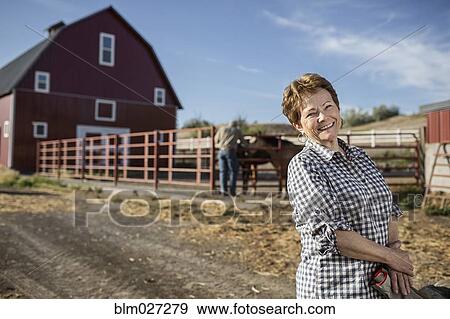 Caucasian rancher standing by barn View Large Photo Image Stock Photo - Caucasian rancher standing by barn. Fotosearch