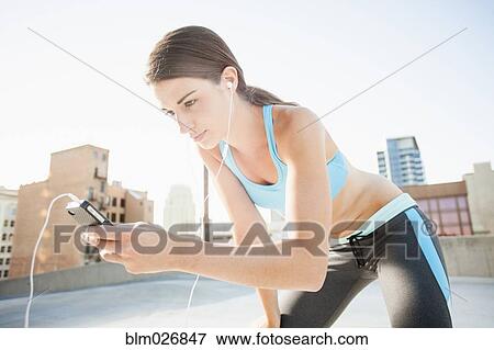 Stock Photo - Caucasian runner listening to headphones. Fotosearch