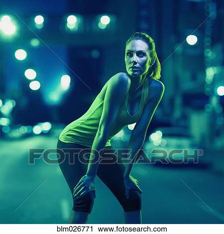 Stock Image - Caucasian runner standing on city street. Fotosearch