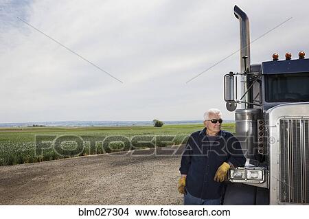 Caucasian trucker standing by truck View Large Photo Image Picture - Caucasian trucker standing by truck. Fotosearch