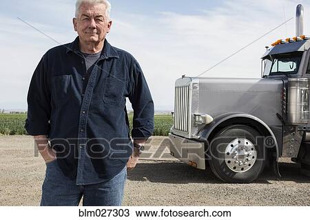 Caucasian trucker standing by truck View Large Photo Image Stock Image - Caucasian trucker standing by truck. Fotosearch