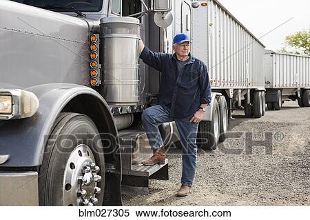 Caucasian trucker standing by truck View Large Photo Image Stock Photography - Caucasian trucker standing by truck. Fotosearch