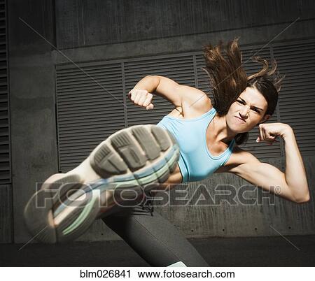 Stock Image - Caucasian woman kicking. Fotosearch