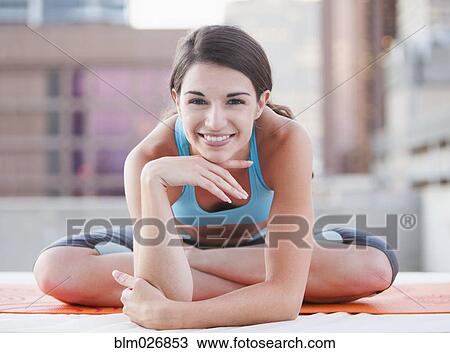 Stock Image - Caucasian woman smiling on urban rooftop. Fotosearch