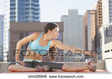 Caucasian woman stretching on urban rooftop View Large Photo Image Stock Photograph - Caucasian woman stretching on urban rooftop. Fotosearch