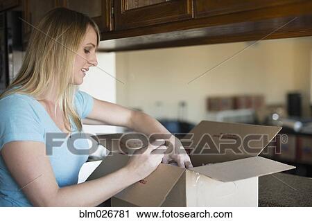 Caucasian woman unpacking in new home View Large Photo Image Stock Image - Caucasian woman unpacking in new home. Fotosearch