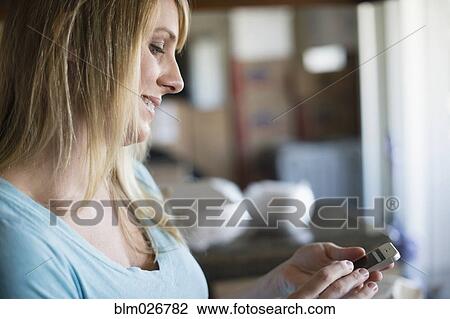 Stock Image - Caucasian woman using cell phone. Fotosearch