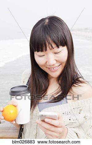 Chinese woman using cell phone outdoors View Large Photo Image Stock Image - Chinese woman using cell phone outdoors. Fotosearch