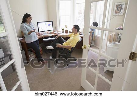 Stock Photograph - Couple talking in home office. Fotosearch