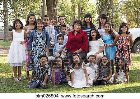 Picture - Family smiling together in park. Fotosearch
