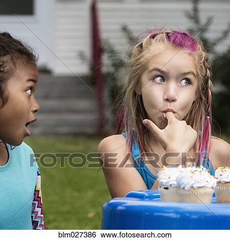 Girls eating cupcakes in backyard View Large Photo Image Stock Photograph - Girls eating cupcakes in backyard. Fotosearch