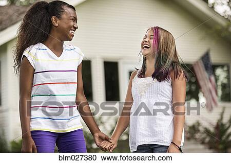 Girls holding hands in backyard View Large Photo Image Stock Image - Girls holding hands in backyard. Fotosearch