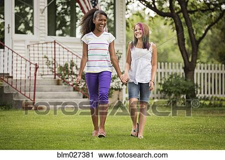 Girls holding hands in backyard View Large Photo Image Stock Image - Girls holding hands in backyard. Fotosearch