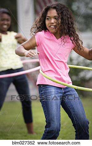 Girls hula hooping in backyard View Large Photo Image Stock Image - Girls hula hooping in backyard. Fotosearch