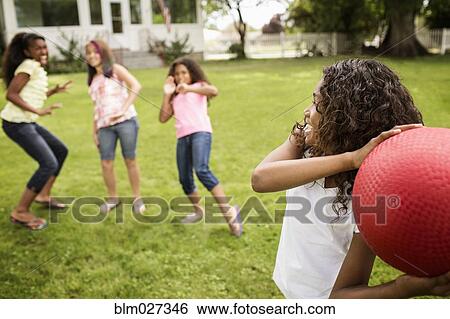 Girls playing dodgeball in backyard View Large Photo Image Stock Photograph - Girls playing dodgeball in backyard. Fotosearch