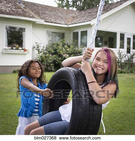 Girls playing on tire swing View Large Photo Image Stock Photo - Girls playing on tire swing. Fotosearch