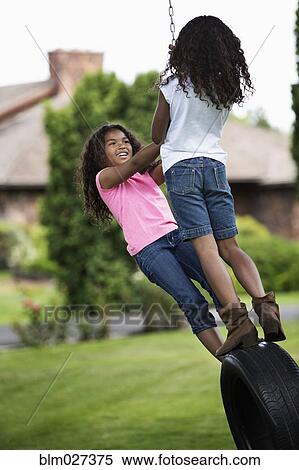 Girls playing on tire swing View Large Photo Image Stock Photography - Girls playing on tire swing. Fotosearch