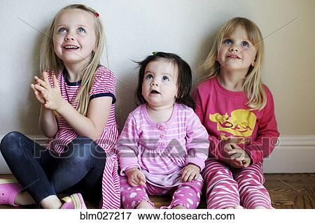 Girls sitting together on floor View Large Photo Image Stock Photo - Girls sitting together on floor. Fotosearch