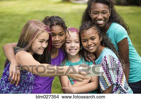 Picture - Girls taking self-portrait in backyard. Fotosearch