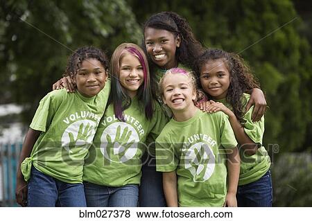 Stock Photo - Girls wearing volunteer t-shirts outdoors. Fotosearch