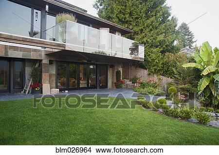 Green lawn behind modern home View Large Photo Image Picture - Green lawn behind modern home. Fotosearch