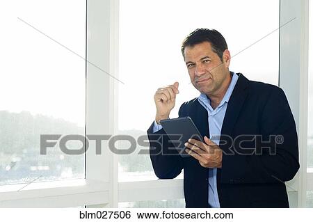 Hispanic businessman using digital tablet View Large Photo Image Stock Photograph - Hispanic businessman using digital tablet. Fotosearch