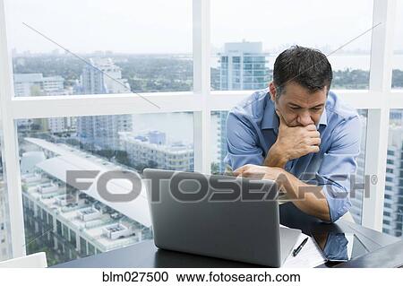 Stock Image - Hispanic businessman working in office. Fotosearch