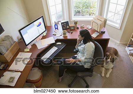 Stock Image - Hispanic businesswoman working at desk. Fotosearch