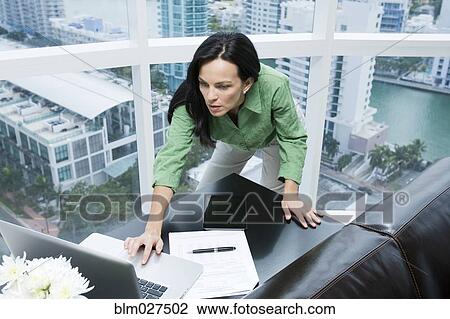 Stock Image - Hispanic businesswoman working in office. Fotosearch