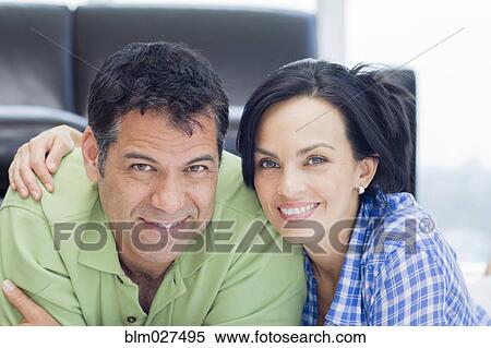 Stock Photography - Hispanic couple smiling in living room. Fotosearch