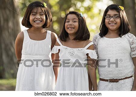 Stock Image - Hispanic girls smiling together. Fotosearch