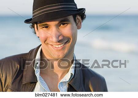 Stock Image - Hispanic man smiling outdoors. Fotosearch