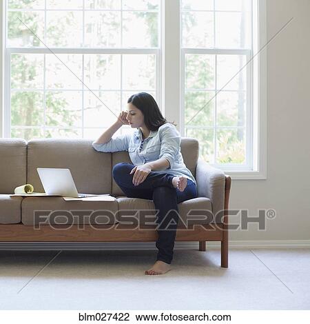 Hispanic woman using laptop on sofa View Large Photo Image Stock Image - Hispanic woman using laptop on sofa. Fotosearch