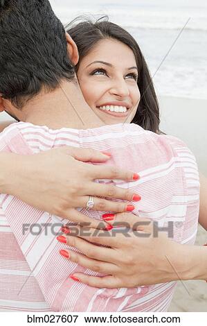 Stock Photo - Indian couple hugging on beach. Fotosearch