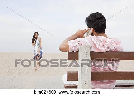 Indian man talking on cell phone on beach View Large Photo Image Stock Photo - Indian man talking on cell phone on beach. Fotosearch