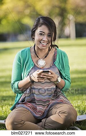 Indonesian woman using cell phone View Large Photo Image Stock Image - Indonesian woman using cell phone. Fotosearch