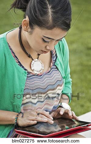 Indonesian woman using digital tablet View Large Photo Image Stock Photography - Indonesian woman using digital tablet. Fotosearch