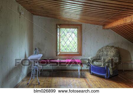 Ironing board, table and armchair in attic View Large Photo Image Stock Photo - Ironing board, table and armchair in attic. Fotosearch