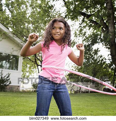 Mixed race girl hula hooping in backyard View Large Photo Image Stock Photo - Mixed race girl hula hooping in backyard. Fotosearch