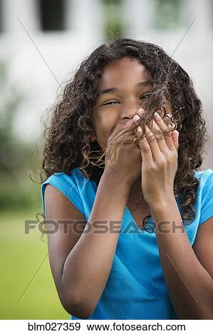 Stock Photo - Mixed race girl laughing outdoors. Fotosearch