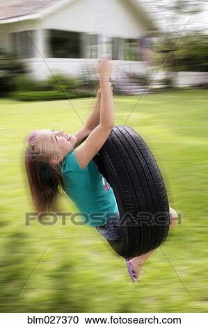 Mixed race girl playing on tire swing View Large Photo Image Stock Image - Mixed race girl playing on tire swing. Fotosearch