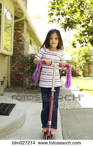 Mixed race girl riding scooter View Large Photo Image Picture - Mixed race girl riding scooter. Fotosearch