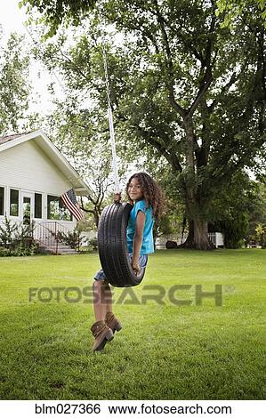Mixed race girl sitting in tire swing View Large Photo Image Stock Photograph - Mixed race girl sitting in tire swing. Fotosearch
